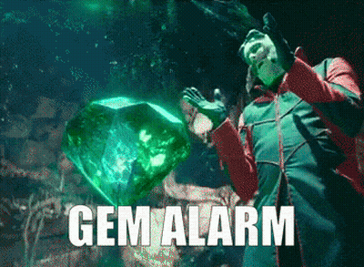 Man In Green Jacket Holding Large Emerald Gem Alarm GIF