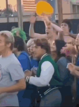 Man In Green Jacket In Crowd GIF