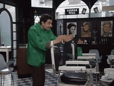 Man In Green Jacket In Front Of Barber Chair GIF