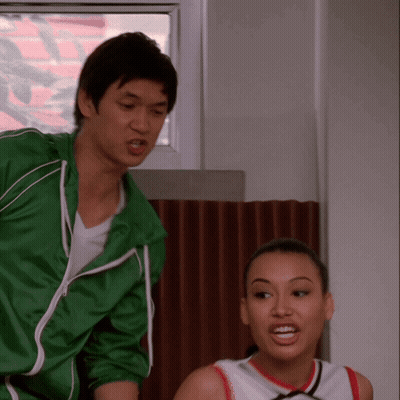 Man In Green Jacket Next To Cheerleader GIF