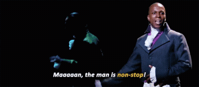 Man In Green Jacket Next To Man In Suit On Stage GIF