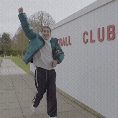 Man In Green Jacket Running In Front Of Ball Club Wall GIF