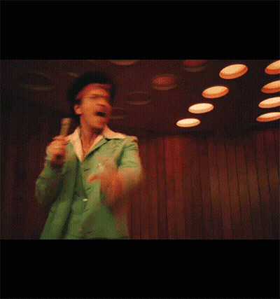 Man In Green Jacket Singing Into Microphone And Pointing GIF