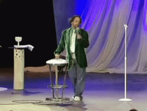 Man In Green Jacket Singing Into Microphone GIF