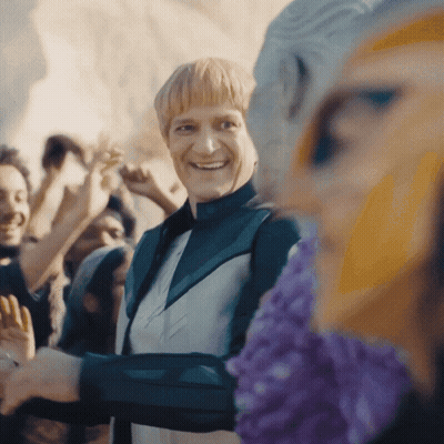 Man In Green Jacket Smiling In Crowd GIF