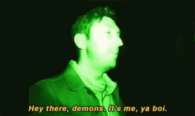 Man In Green Jacket Talking In Dark Room GIF