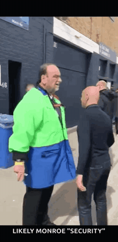 Man In Green Jacket Talking To Another Man GIF