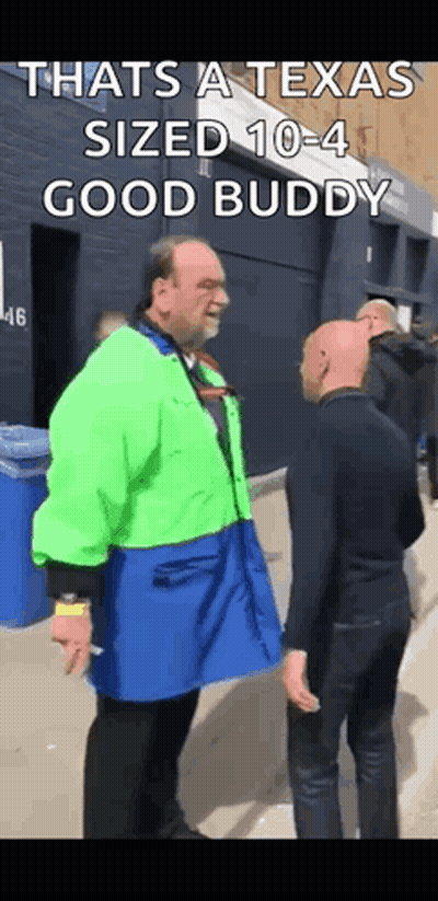 Man In Green Jacket Talking To Man In Blue Apron GIF