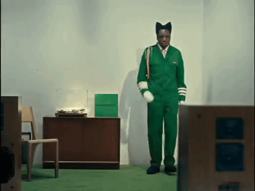 Man In Green Jumpsuit In Front Of Record Player GIF