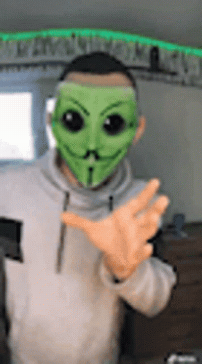 Man In Green Mask Making Peace Sign GIF