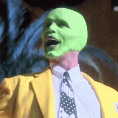 Man In Green Mask, Yellow Suit, And Tie GIF
