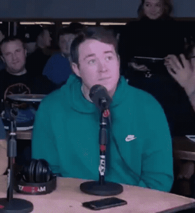 Man In Green Nike Sweatshirt With Microphone GIF