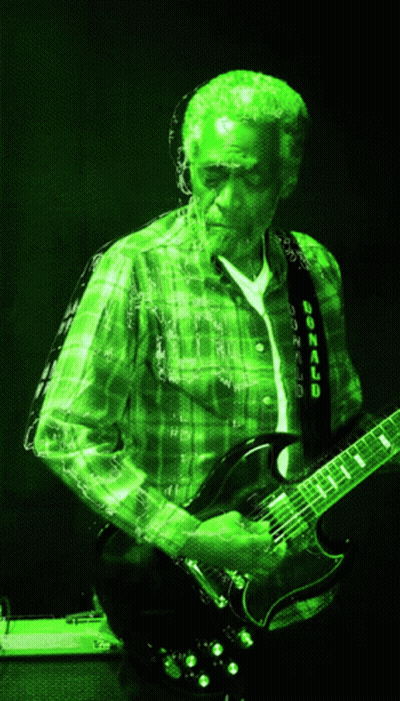 Man In Green Plaid Shirt Playing Guitar With Bonnaroo Strap GIF
