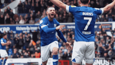 Man In Green Puma Shirt In Front Of Brick Wall Equals Three GIF