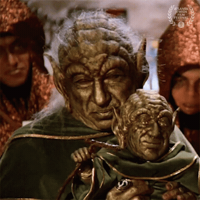 Man In Green Robe Holding Puppet GIF