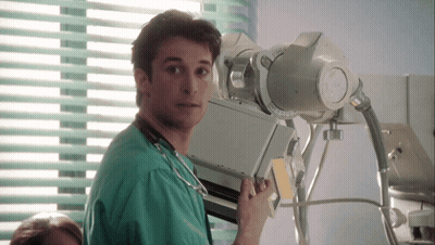 Man In Green Scrub Holding X-Ray Machine In Front Of Window GIF