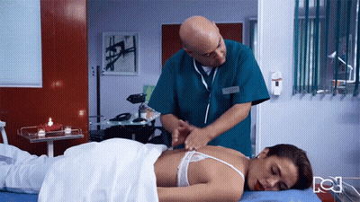Man In Green Scrub Massaging Woman In Hospital GIF