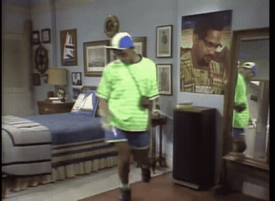 Man In Green Shirt And Blue Hat In Bedroom GIF