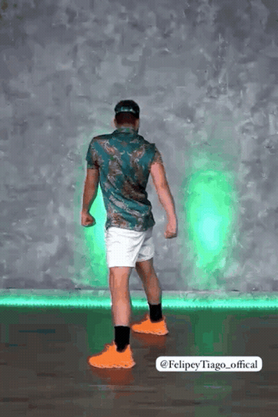 Man In Green Shirt And White Shorts In Front Of Green Light GIF