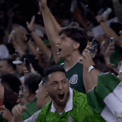 Man In Green Shirt Cheering In Crowd GIF