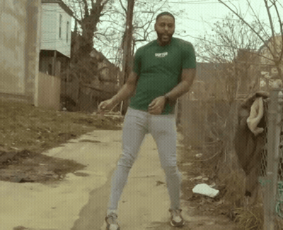 Man In Green Shirt Dancing On Dirt Road GIF