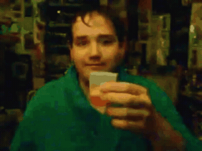 Man In Green Shirt Drinking From Cup GIF