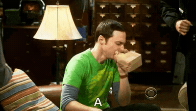 Man In Green Shirt Eating Food On Couch GIF