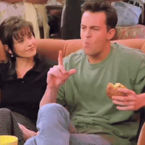 Man In Green Shirt Eating Sandwich On Couch GIF