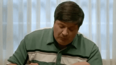 Man In Green Shirt Eating With Eyes Closed GIF