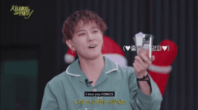 Man In Green Shirt Holding Glass Saying Merry Christmas GIF