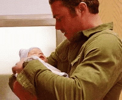 Man In Green Shirt Holding Newborn Baby GIF