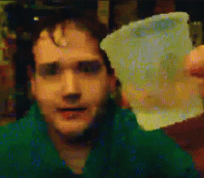 Man In Green Shirt Holding Plastic GIF