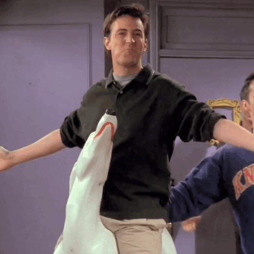 Man In Green Shirt Holding Stuffed Shark GIF