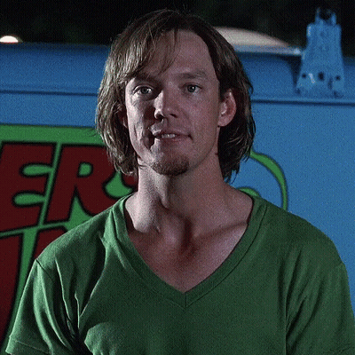 Man In Green Shirt In Front Of Scooby Doo Vehicle GIF