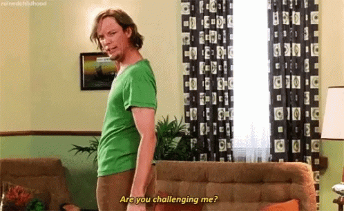 Man In Green Shirt In Living Room Next To Couch And Lamp GIF
