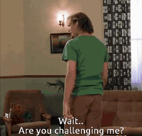 Man In Green Shirt In Living Room Saying Wait Are You Challenging Me GIF
