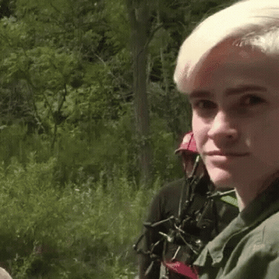 Man In Green Shirt Looking In Distance In Woods GIF