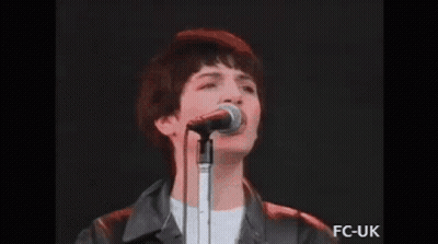 Man In Green Shirt Playing Guitar With Band GIF