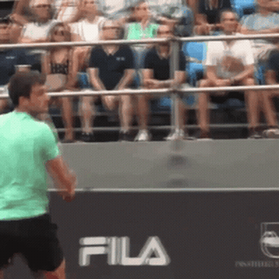 Man In Green Shirt Playing Tennis In Front Of Fila Banner GIF