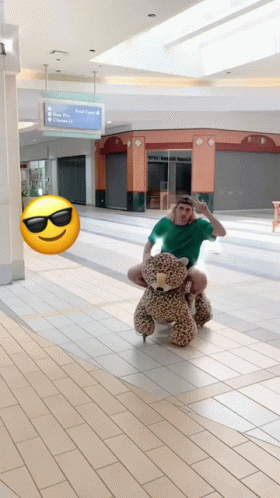 Man In Green Shirt Riding Teddy Bear GIF