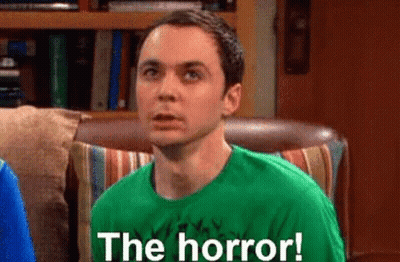 Man In Green Shirt Says The Horror On Couch GIF