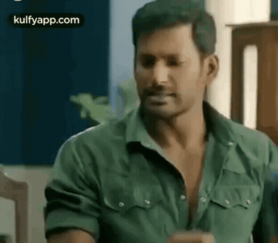 Man In Green Shirt Sitting In Chair GIF