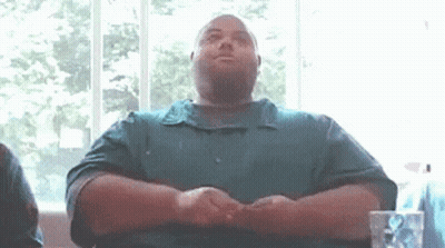 Man In Green Shirt Sitting With Folded Hands GIF