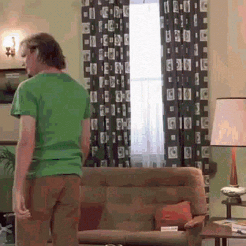Man In Green Shirt Standing In Living Room GIF