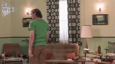 Man In Green Shirt Standing Next To Couch GIF