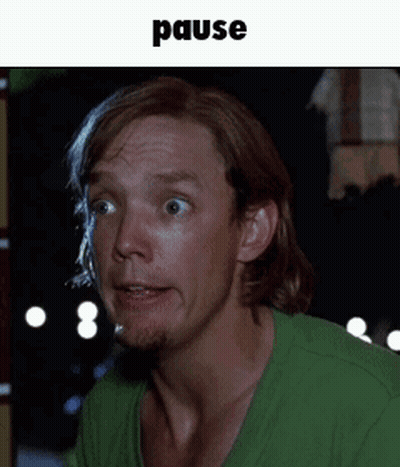 Man In Green Shirt With Pause Above GIF