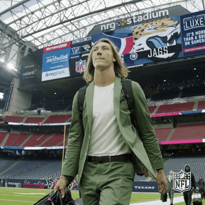Man In Green Suit Walking Past NFL Sign GIF