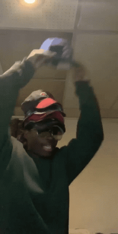 Man In Green Sweater And Sunglasses Holding Hat GIF