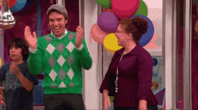 Man In Green Sweater Standing Next To Woman In Purple Dress GIF