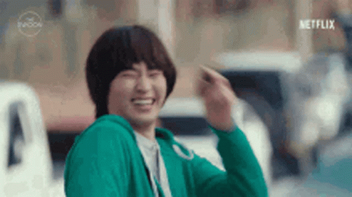 Man In Green Sweater Waving And Laughing GIF
